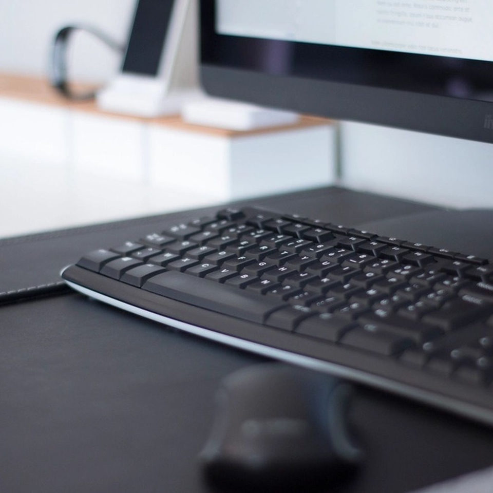 A black desk mat under a keyboard