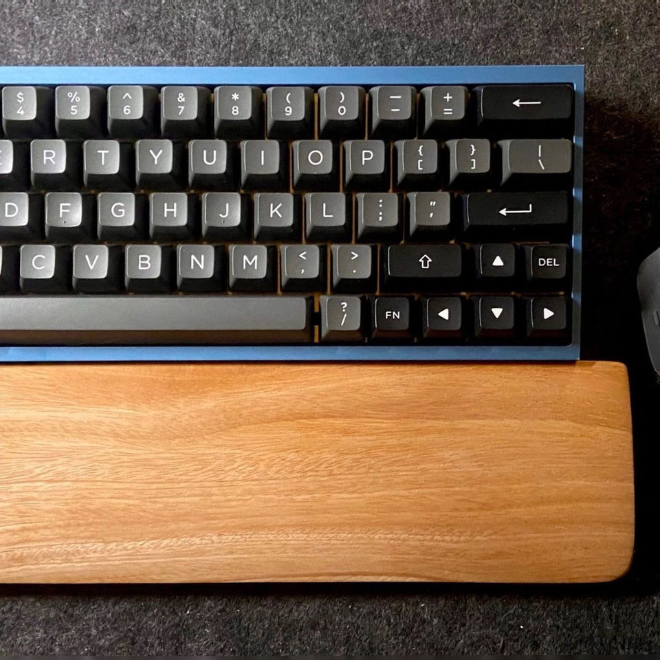 A keyboard and wrist rest on a felt desk mat